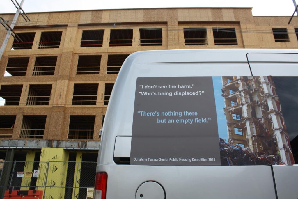 "I don't see the harm." "Who's being displaced?" "There's nothing there but an empty field." Design on van with demolished building with new construction behind it