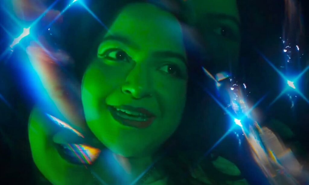 Still frame from video with face lit in green light